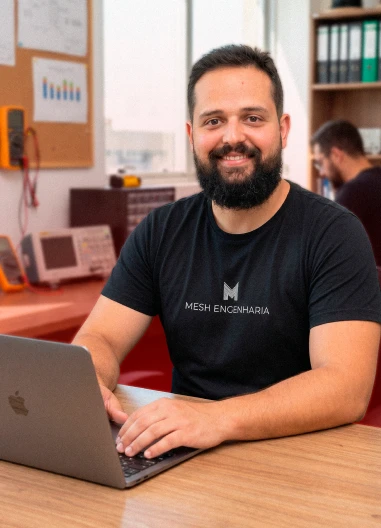Eng. Hilton, da Mesh Engenharia, sentado à mesa com seu notebook